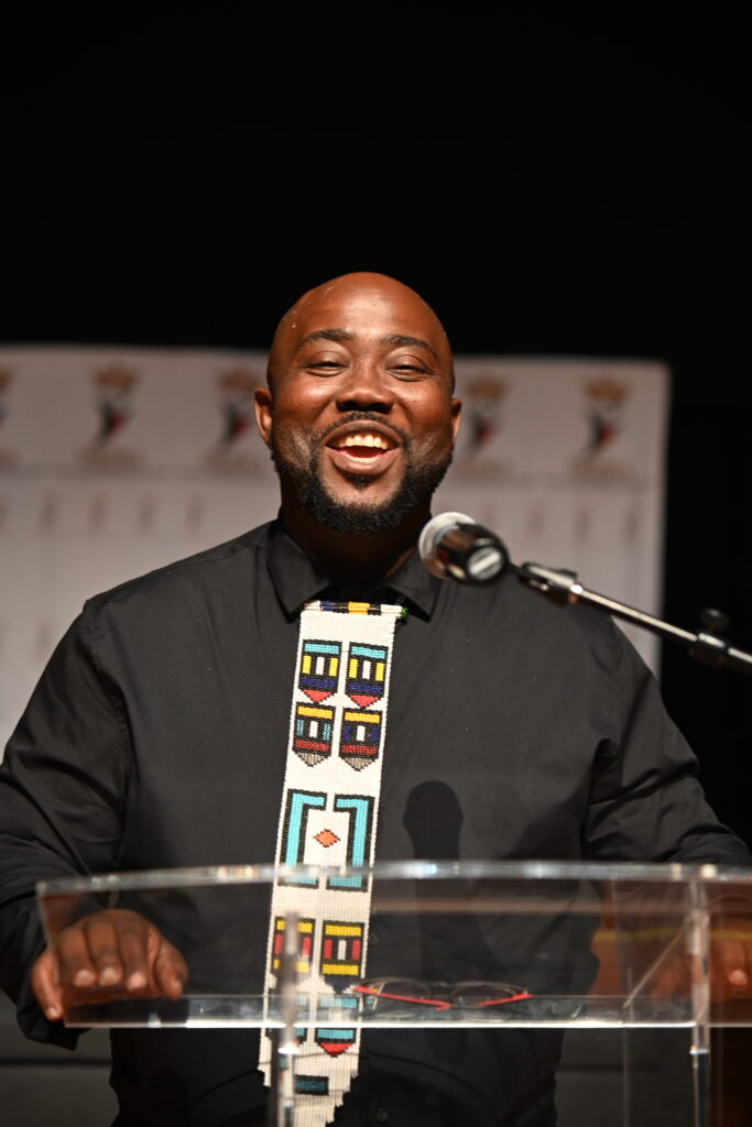 Thandwefika Tshabalala laughing at the lectern during an event